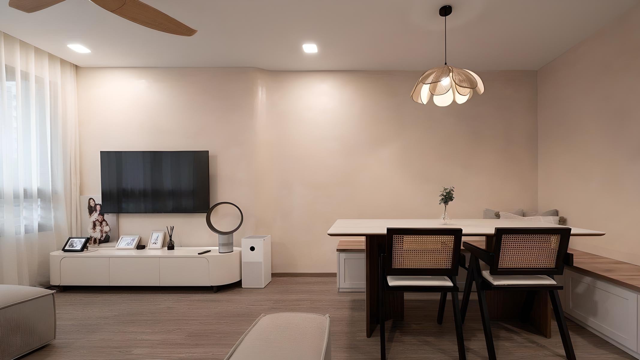 Modern living room with a television, table, and chairs.